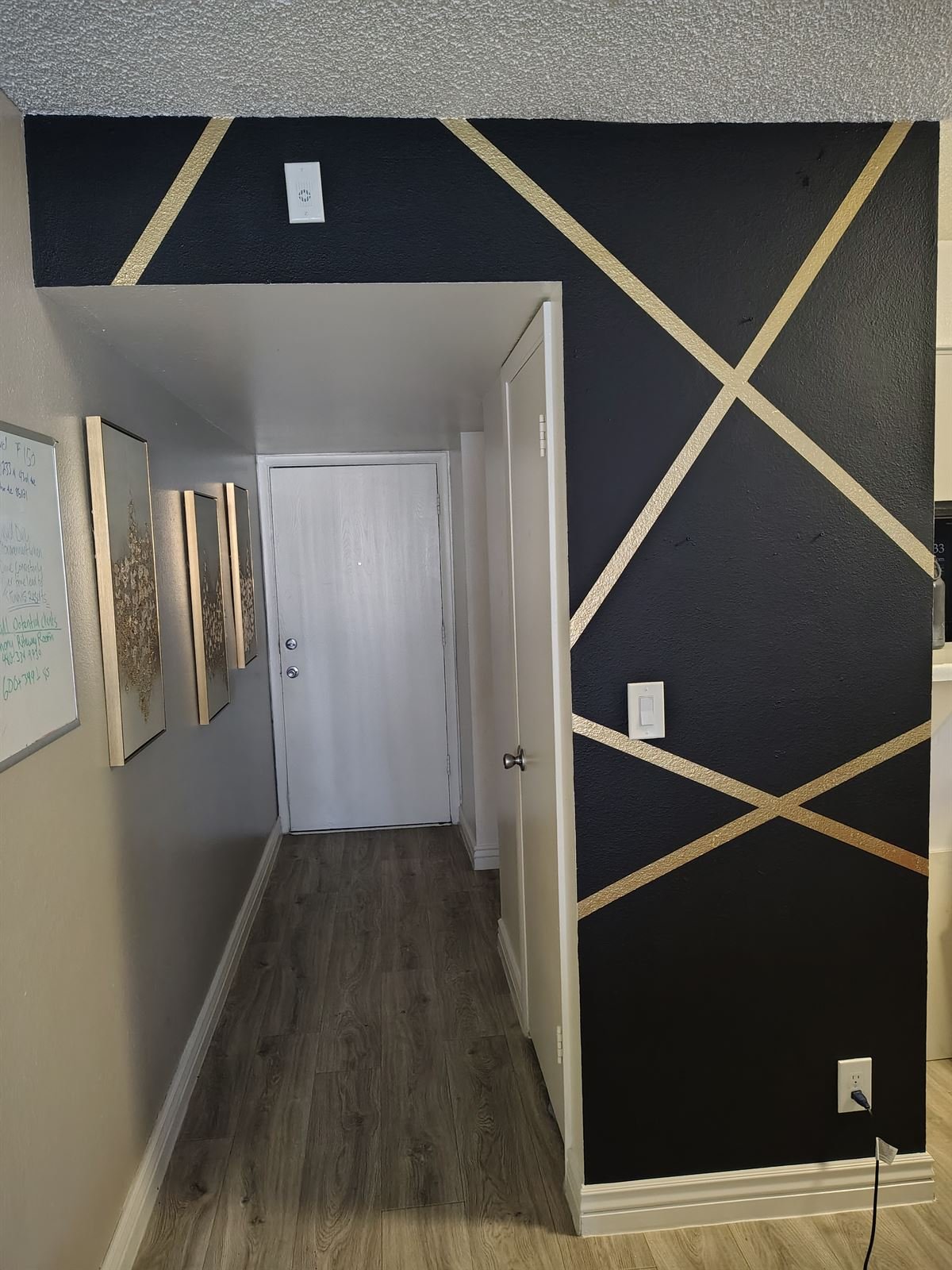 Black accent wall with gold geometric lines