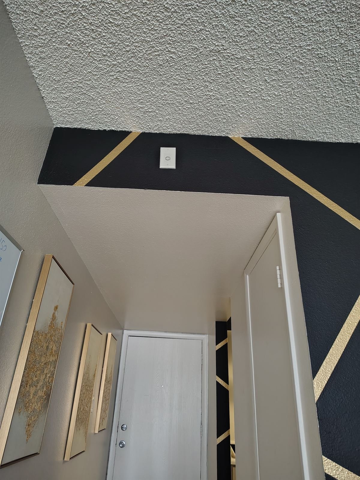 Black and gold geometric wall along entry hallway